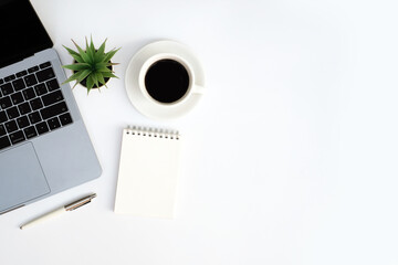 Wall Mural - Workspace office business and education concept on white table desk background with laptop computer and blank notepad, coffee cup and green plant, Top view with copy space, flat lay