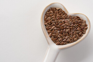 Wall Mural - Brown Flaxseeds on a Heart Shaped Spoon