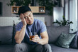 © Liubomir - Asian man at home alone, depressed drinking strong alcohol, single man