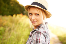 Relaxed Country Beauty. Beautiful Young Woman In A Field While Wearing A Straw Fedora.