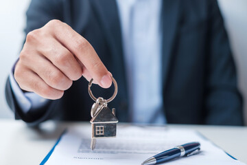 Wall Mural - man holding home key during signing home contract documents. Contract agreement, real estate,  buy and sale and insurance concepts