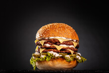 Quadruple Burger With Cheese Cucumber And Lettuce. Isolated On Black Background..