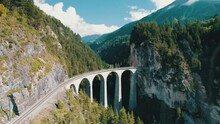 Landwasser Viaduct In The Swiss Alps In Summer, Aerial View. Panoramic View Of A Green Mountain Valley. Famous Viaduct In A Mountain Gorge. Glacier Express In Switzerland, Graubunden, Bernina Pass. 4K