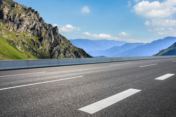 Empty asphalt road and mountain nature scenery under blue sky. Road and mountain background.