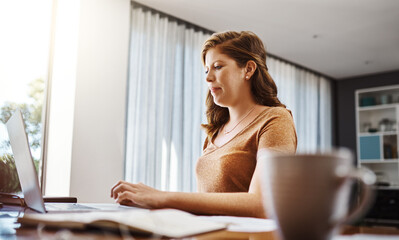 Poster - Everyday is chance for you to work hard and achieve. Shot of an attractive young businesswoman sitting down and using her laptop while working from home.