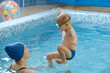 © ninelutsk - Toddler child learning to swim in indoor swimming pool with teacher. balancing in the water and general physical activity for kids, early development. Boy kid trained to kick legs