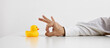 Job dismissal, unemployment or being fired from a work. Businessman hand is about to flick the rubber duckling.