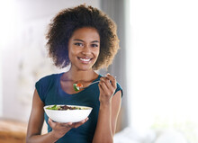 Getting Her Greens. Portrait Of An Attractive Young Woman Eating A Bowl Of Salad.