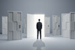 Businessman standing in front of abstract white puzzle door in interior. Future, choice, success, direction, opportunity and solution concept.