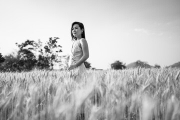 Beautiful woman standing in middle of barley field black and white picture.