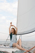 © Ivan Kozachenko - A redhead woman posing sitting on a yacht in the middle of the sea
