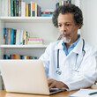© Daniel Ernst - African american senior doctor working at computer