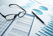Many Reports With Graphs And Figures. Glasses And Pen. Financial Analysis And Management Concept.