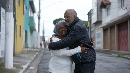 Wall Mural - A Brazilian son embracing a senior mother in 80s outside portrait