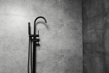 Wall Mural - Black freestanding bath taps, on the background of dark grey bathroom walls.