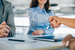 © bnenin - Close-up photo of two female colleagues shaking hands.