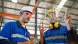 © bung - Engineer wearing safety helmet and glasses and explain the project diagram with manager in the manufacturing factory. Worker holding transparent futuristic tablet. Industrial, technology concept.