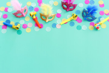 Wall Mural - Holidays image of colorful masks over green background. view from above