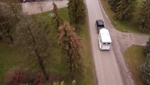 Black Pick Up Truck Towing Horse Trailer Through Small Town, Aerial Follow View