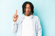 © Asier - Young African American man isolated on blue background pointing upside with opened mouth.