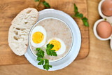 Fototapeta Tulipany - Traditional Polish soup served with bread and eggs. Easter decoration. Sour soup