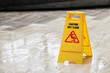 © Rattanachat - caution wet floor sign on wet floor after raining.
