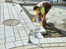 Paver Arranging Cement Paving Stone On Footpath