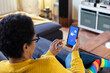 © Westend61 - Woman using app on smart phone in living room