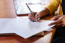 Freelancer Signing Paper Document On Desk At Home