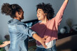 © Westend61 - Cheerful female friends dancing in living room at home