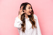 © Asier - Young caucasian woman isolated on pink background trying to listening a gossip.