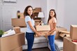 © Krakenimages.com - Woman and girl mother and daughter holding package at new home