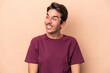 © Asier - Young caucasian man isolated on beige background laughs and closes eyes, feels relaxed and happy.