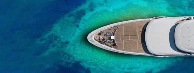 Wall Mural - Aerial drone ultra wide top down photo of luxury exotic yacht nose with wooden deck anchored in paradise turquoise bay