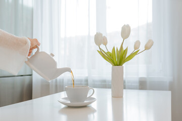 Wall Mural - A woman's hand pours tea from a teapot