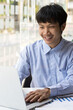© Wasan - Portrait of a businessman working on a laptop on a desk in the office.