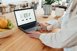 © Westend61 - Woman creating web page for ceramics on laptop at workshop