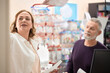 © Westend61 - Female pharmacist holding prescription talking with customer at checkout counter