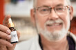 © Westend61 - Pharmacist holding bottle of cannabis oil at pharmacy