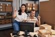 © Krakenimages.com - Young hispanic people working at small business ecommerce smiling with an idea or question pointing finger with happy face, number one