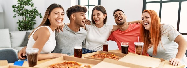 Sticker - Group of young people smiling happy and hugging eating italian pizza at home.