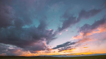 Wall Mural - 4K Countryside Rural Field Landscape With Young Green Wheat Sprouts In Spring Springtime Cloudy Day. Agricultural Field. 4K time-lapse, timelapse. Sunset Evening Time. sunset video, horizon sunset.