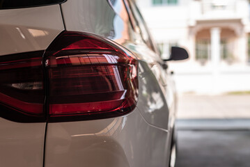 Closeup of car tail light on a white car.