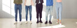 © Studio Romantic - Group of young people in smart casual clothes. Team of men and women in jeans and pants standing in the office together. Cropped, low section shot of human legs. Banner, header background