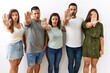 © Krakenimages.com - Group of young hispanic friends standing together over isolated background doing stop gesture with hands palms, angry and frustration expression