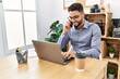 © Krakenimages.com - Young arab man talking on the smartphone using laptop working at office