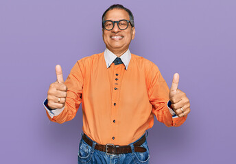 Poster - Middle age indian man wearing casual clothes and glasses approving doing positive gesture with hand, thumbs up smiling and happy for success. winner gesture.