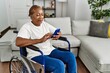 © Krakenimages.com - Senior african american woman using smartphone sitting on wheelchair at home