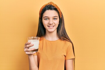 Sticker - Young brunette girl drinking a glass of milk looking positive and happy standing and smiling with a confident smile showing teeth