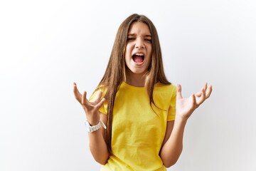 Sticker - Young brunette teenager standing together over isolated background crazy and mad shouting and yelling with aggressive expression and arms raised. frustration concept.